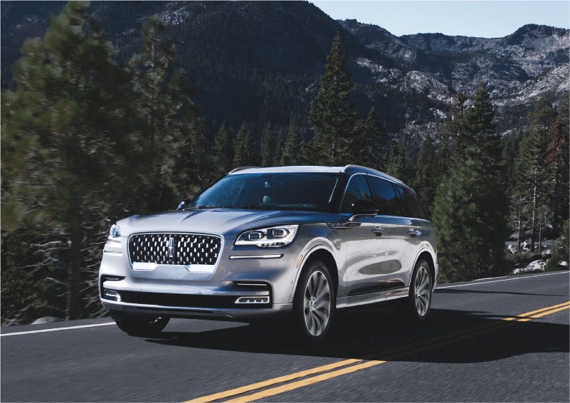 A 2023 Lincoln Aviator® Grand Touring SUV being driven on a winding road to demonstrate the capabilities of all-wheel drive | Parks Lincoln of Gainesville in Gainesville FL