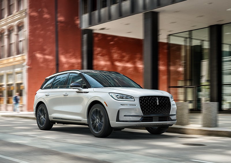 The 2024 Lincoln Corsair® SUV with the Jet Appearance Package and a Pristine White exterior is parked on a city street. | Parks Lincoln of Gainesville in Gainesville FL
